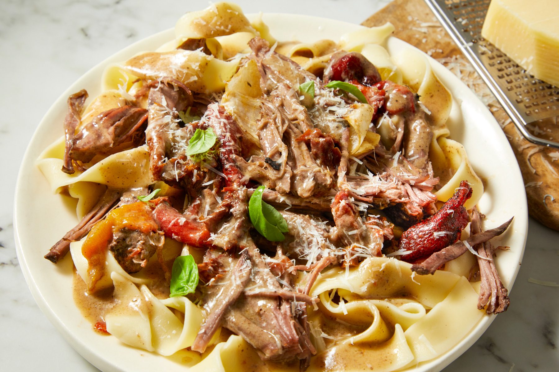 Marry Me Pot Roast served on plates on a marble countertop,