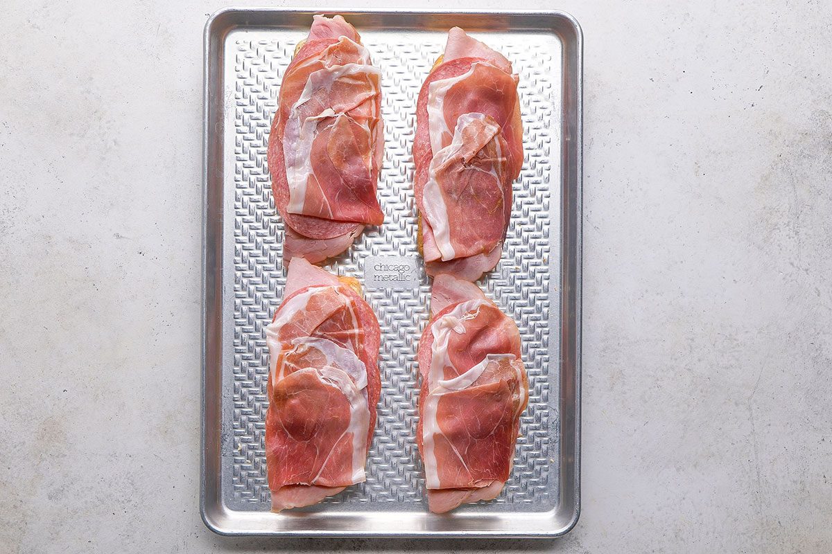 Grinder Sandwich, meat slices topped on the toast in eight pieces on a tray 