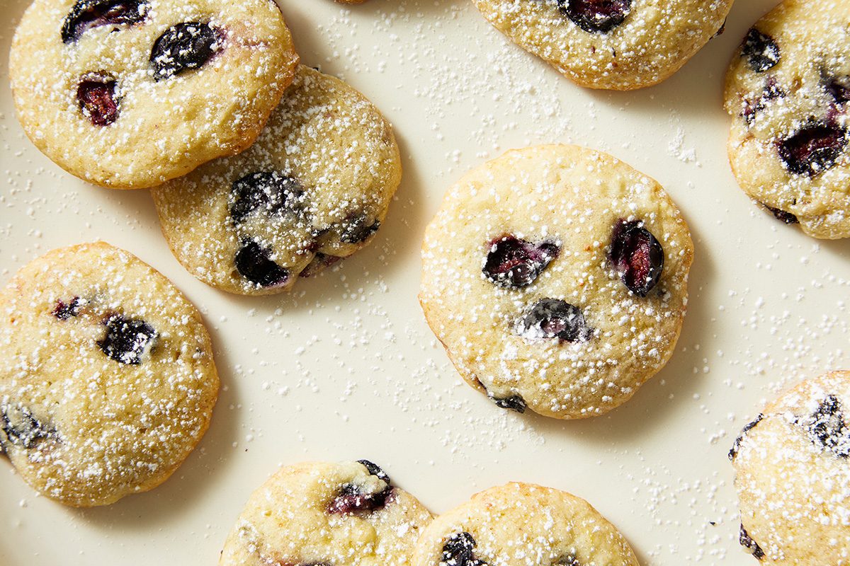 A plate filled with cookies, each adorned with plump blueberries, invitingly displayed for enjoyment.