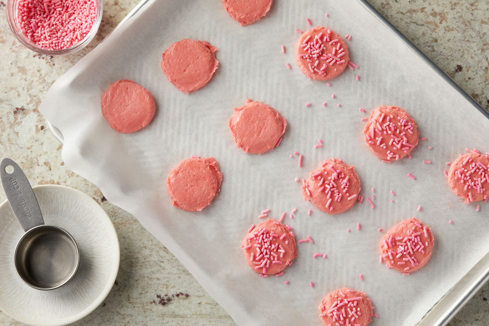 Overhead shot of flatten slightly with a greased measuring cup; top with sprinkles; Bake until edges are just set 10-12 minutes; all arranged on a marble surface