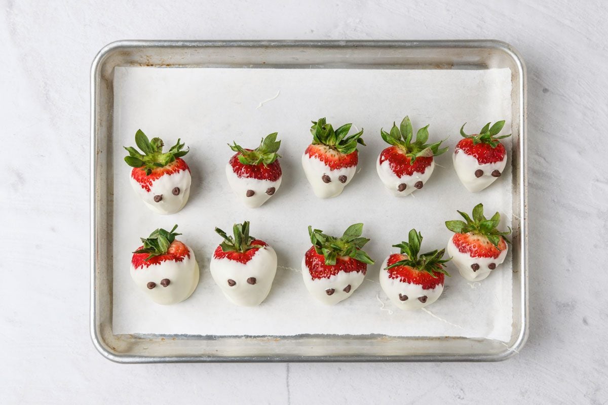 Dip a toothpick into melted chocolate and draw a mouth on each ghost.