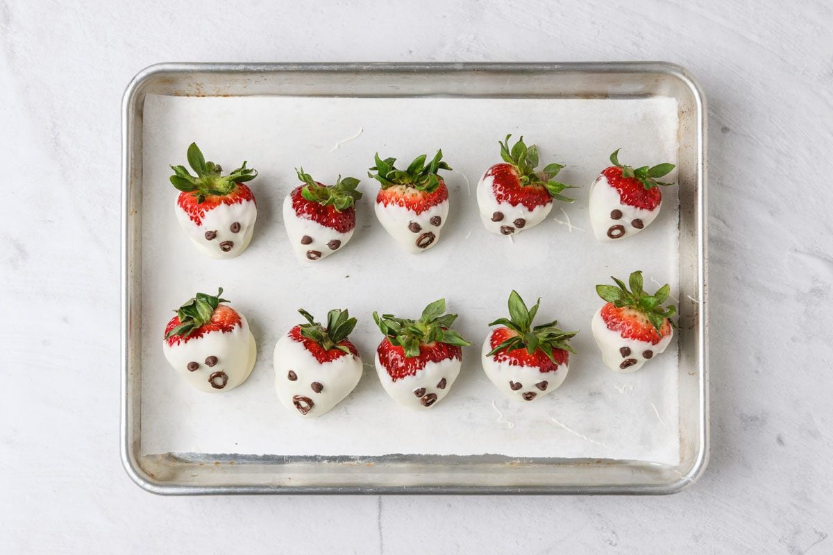Dip a toothpick into melted chocolate and draw a mouth on each ghost.
