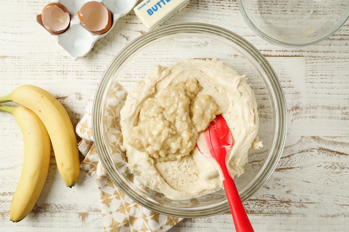 mashed bananas added to batter in a bowl