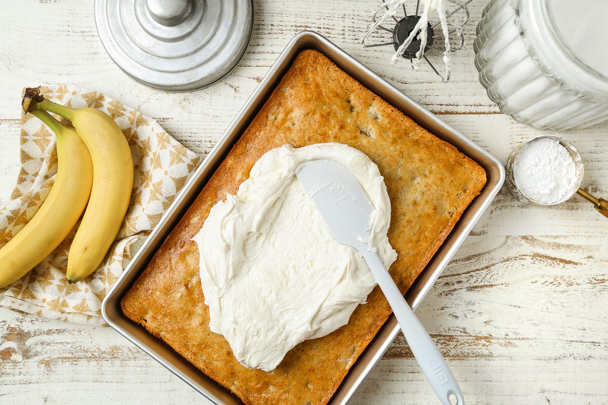 frosting being spread over baked banana bars