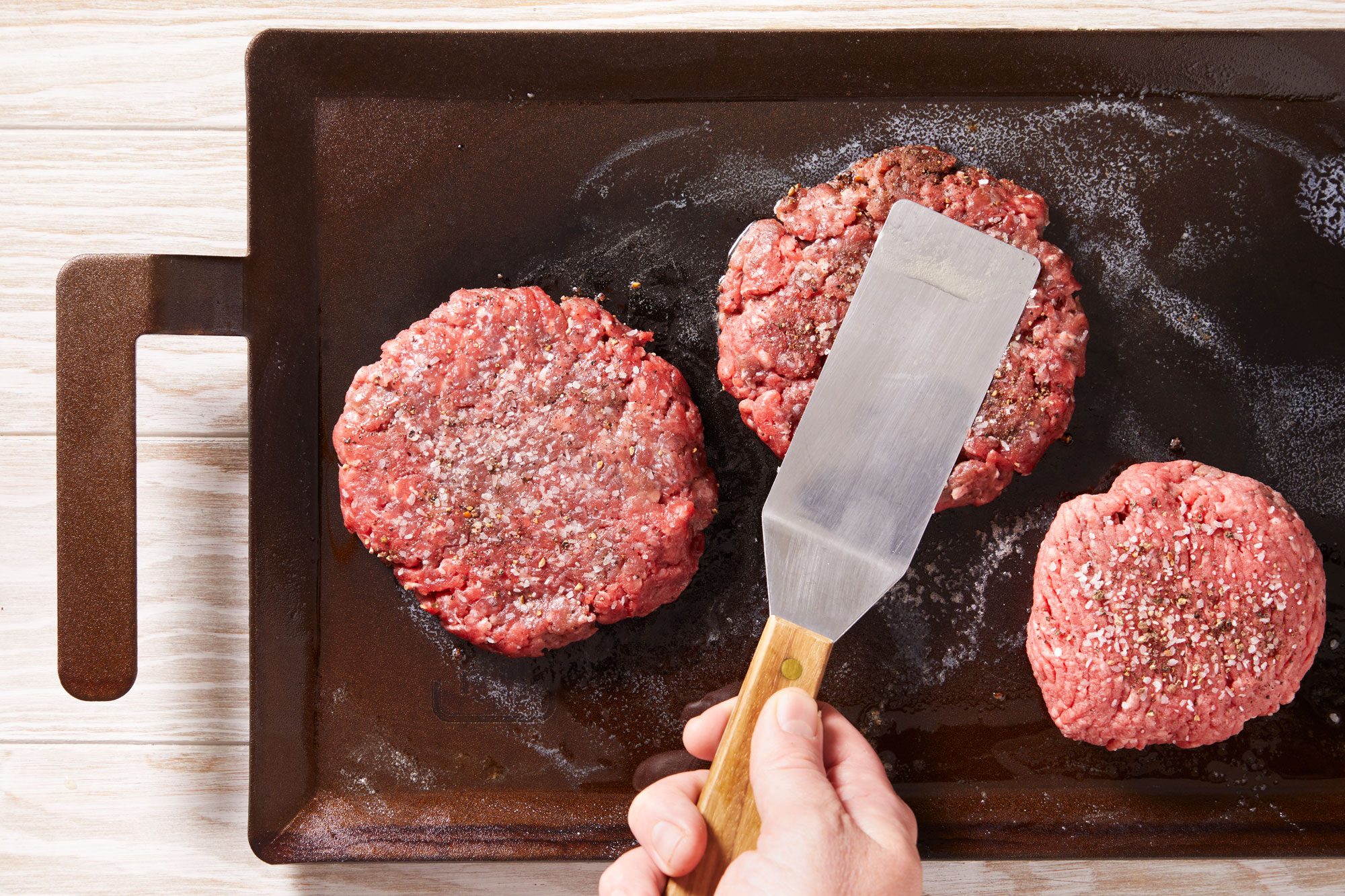 With a heavy metal spatula or burger press, flatten each patty to 1/4-in. thickness.
