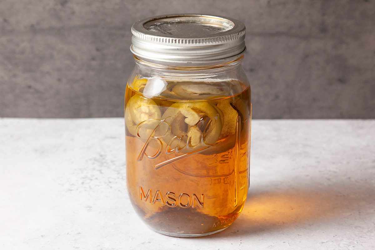 pour 12 ounces rye whiskey in a mason jar. Place jalapeno pepper in the jar. Secure lid on top