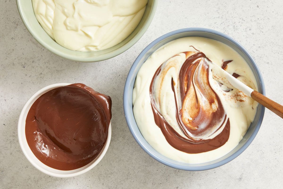 Divide batter in half. Stir melted chocolate into one portion; pour over crust.