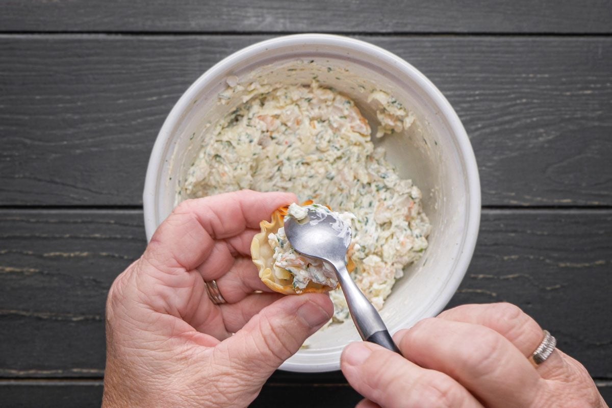 Spoon filling into tart shells.