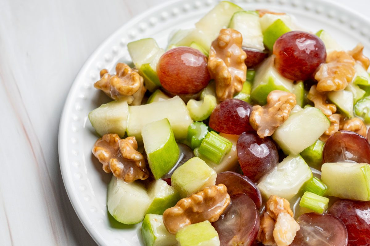 Closeup shot of Apple Grape Salad; served on plate; all set on a marble surface.”
