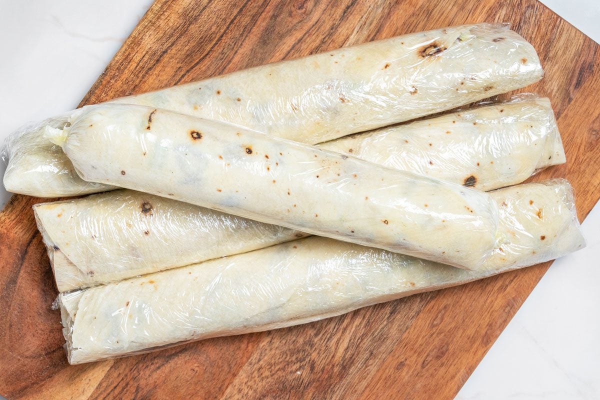 Closeup shot of refrigerate for at least 1 hour; Cut each roll-up into 10 slices on wooden board; all et on a white marble surface;