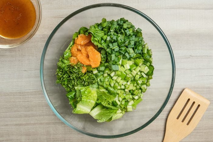 romaine, mandarin oranges, celery, green onions and fresh parsley in a bowl