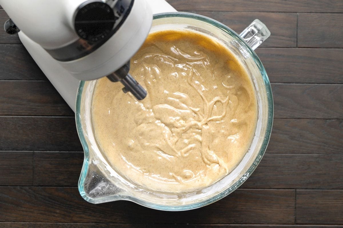 Overhead shot of combine dry ingredients; add to batter; Beat 4 minutes; all set on a dark wooden surface;