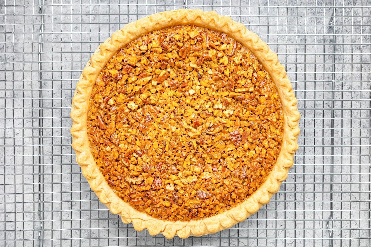 overhead shot of a pecan pie on a cooling rack