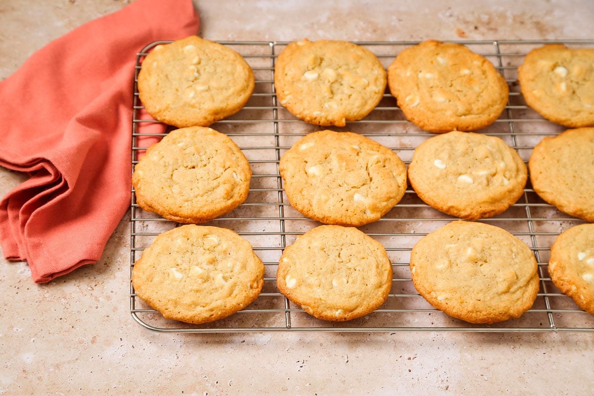 3/4 angle view shot of Orange Creamsicle Cookies; Remove from pans to wire racks to cool; orange napkin nearby; all set on a texture marble surface;