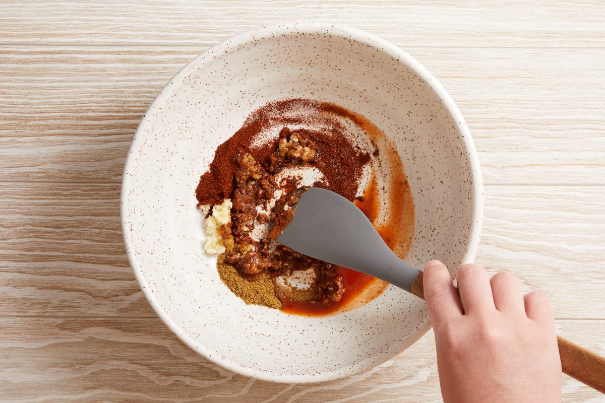 hot sauce combined with cumin, chili powder, garlic, salt and pepper in a large bowl