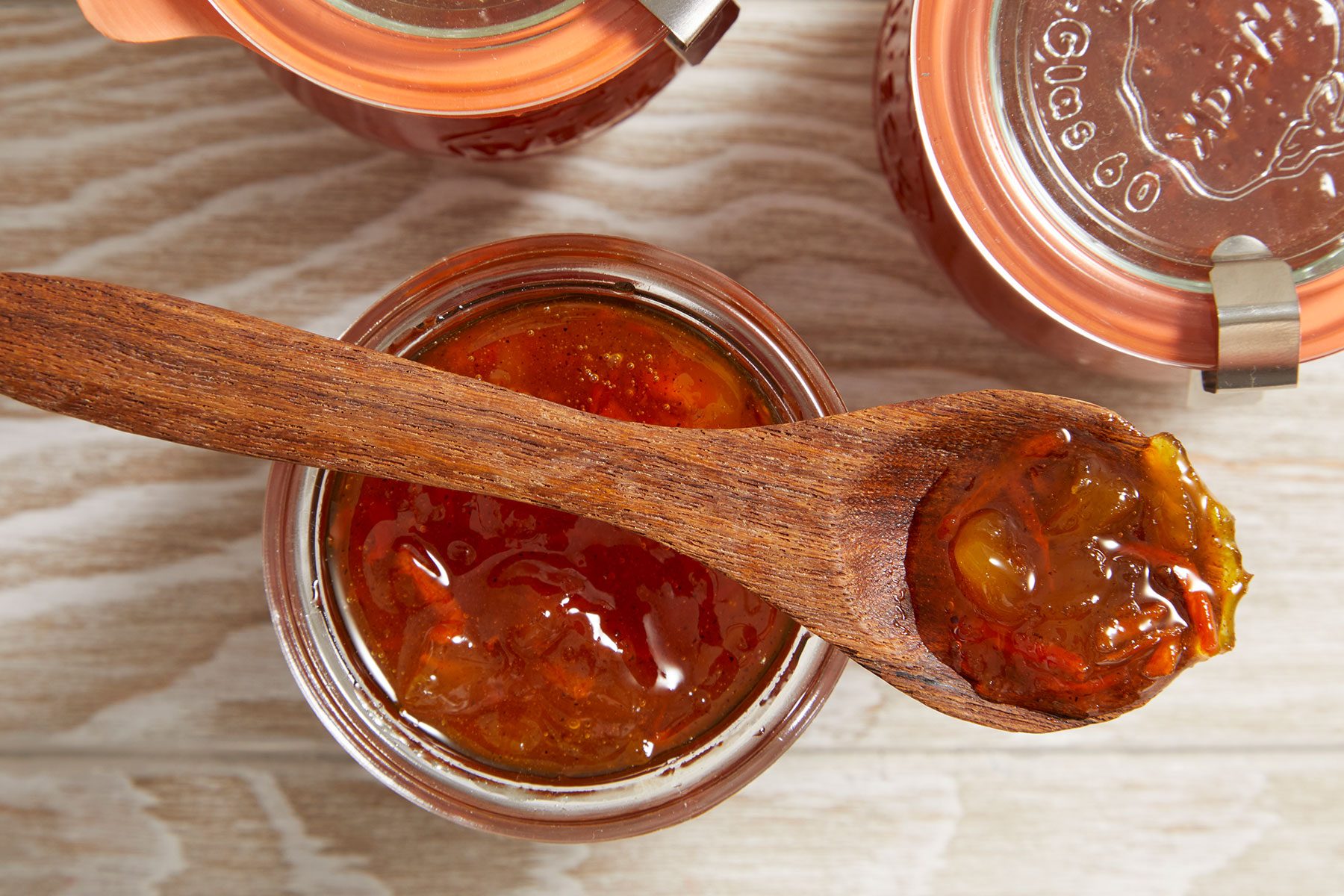 Carrot Cake Jam filled in jars with a wooden spoonful of jam placed on one of the open jars.