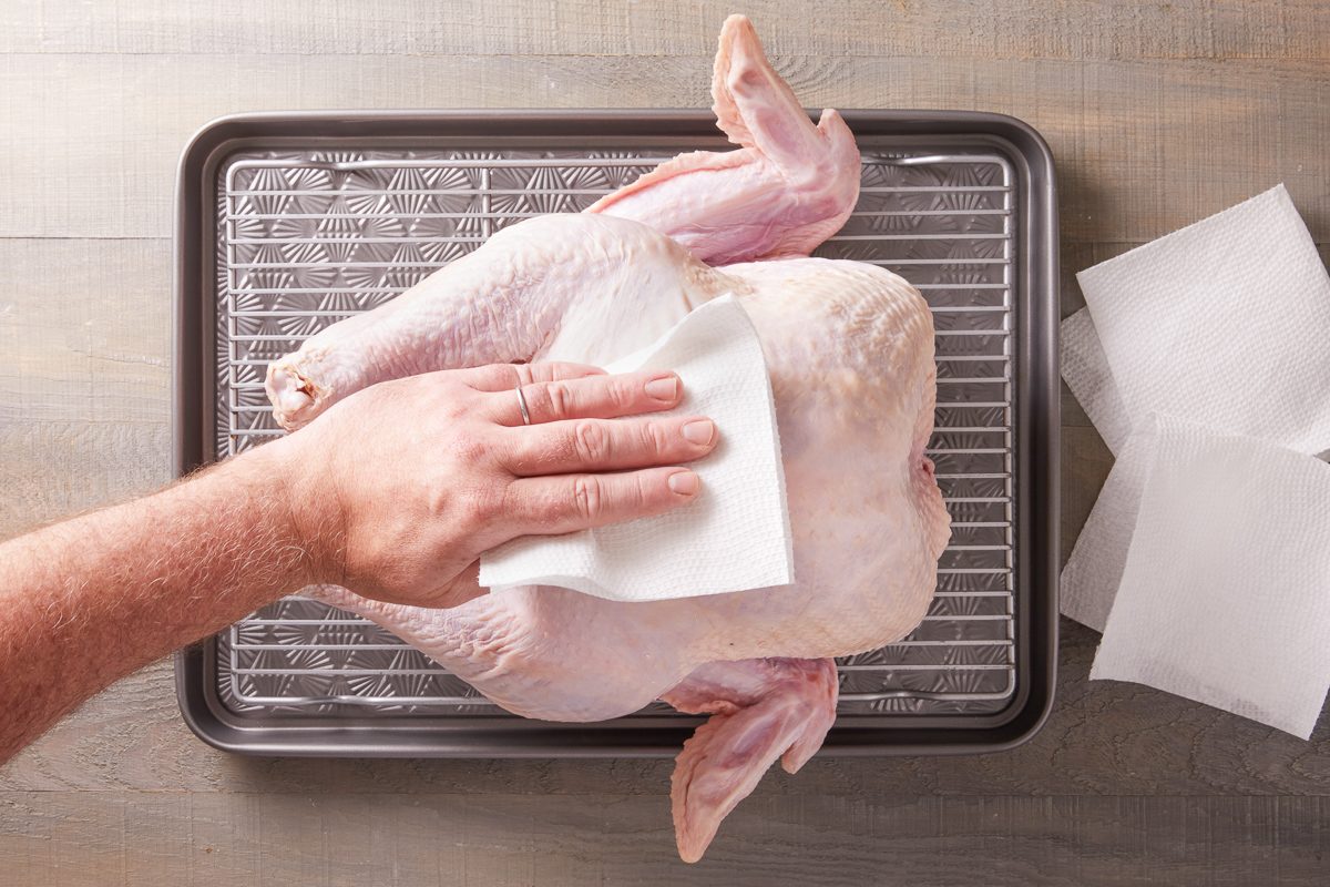 patting turkey dry with paper towels