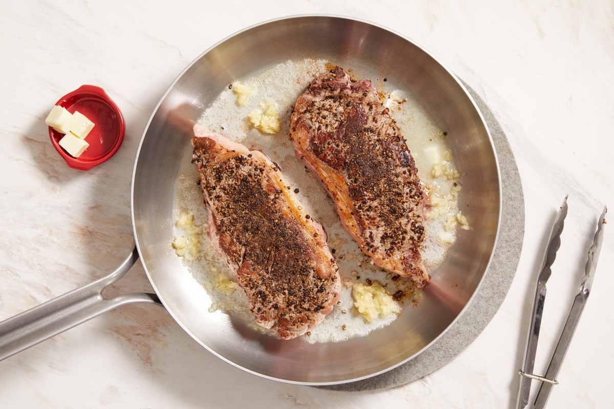 Reduce heat to medium; add butter and garlic;