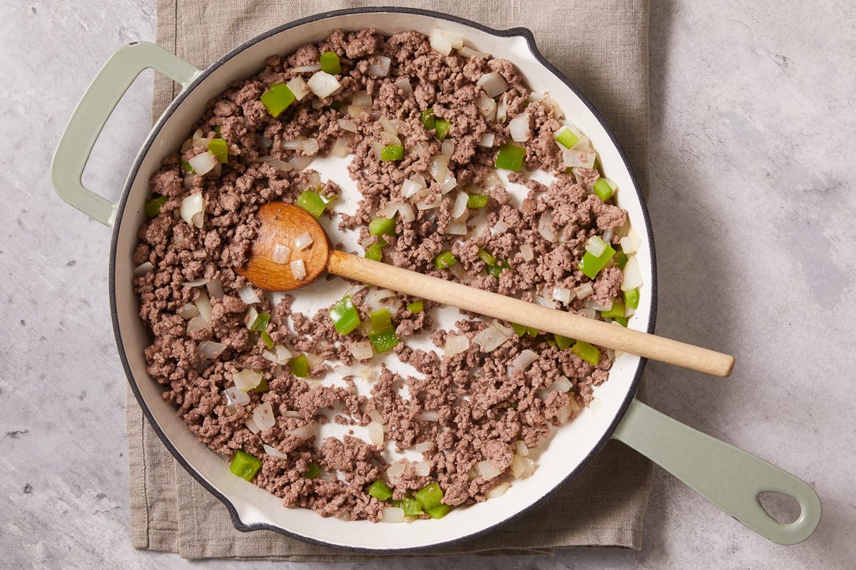ground beef in a large skillet with chopped onions and green pepper