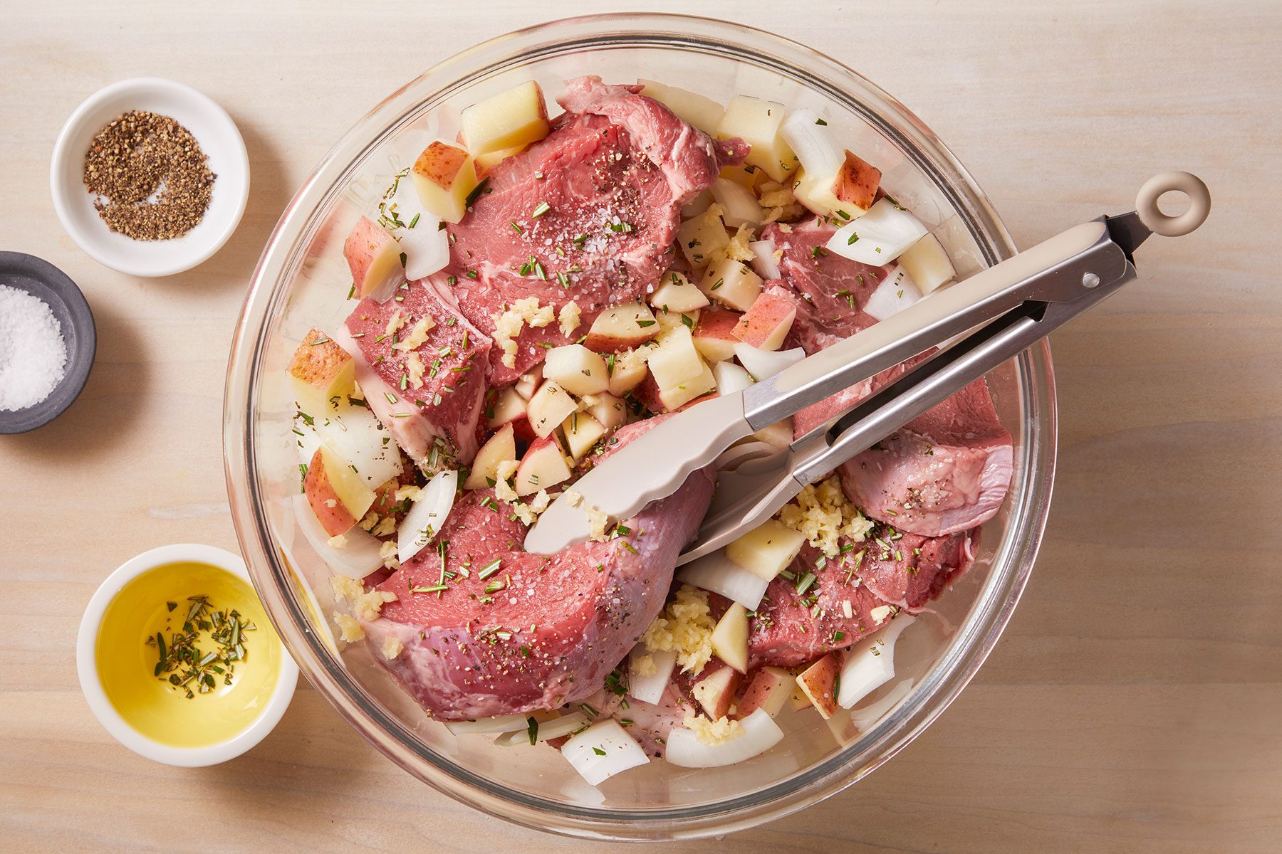 Combined steak, potatoes, onion, rosemary, garlic, salt and pepper in a large bowl.