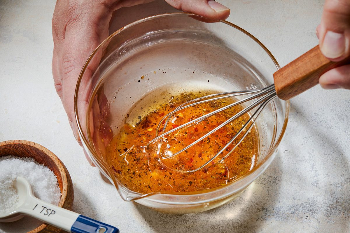 whisking hot honey, oil, salt, pepper and garlic powder together