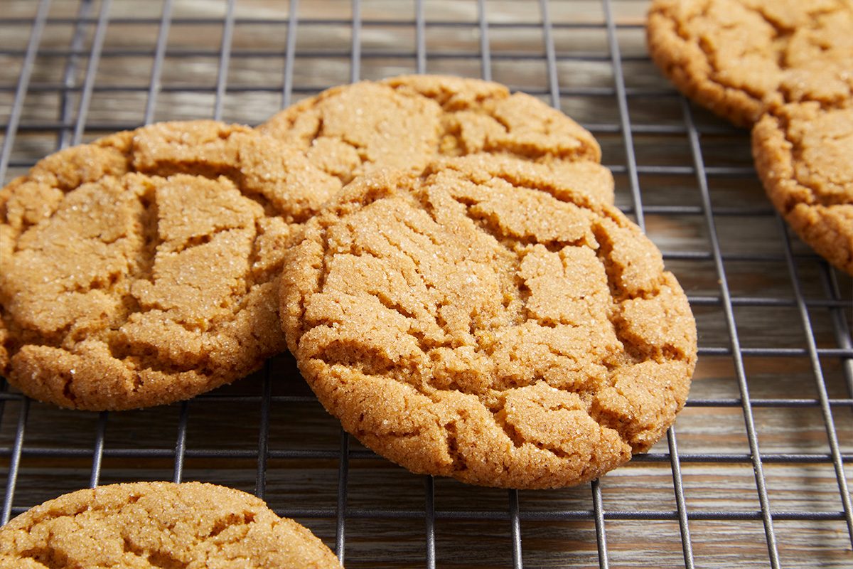 Close-up overhead view of several Cinnamon Crackle Cookies on a cooling rack, showing their crinkled tops and golden brown edges.