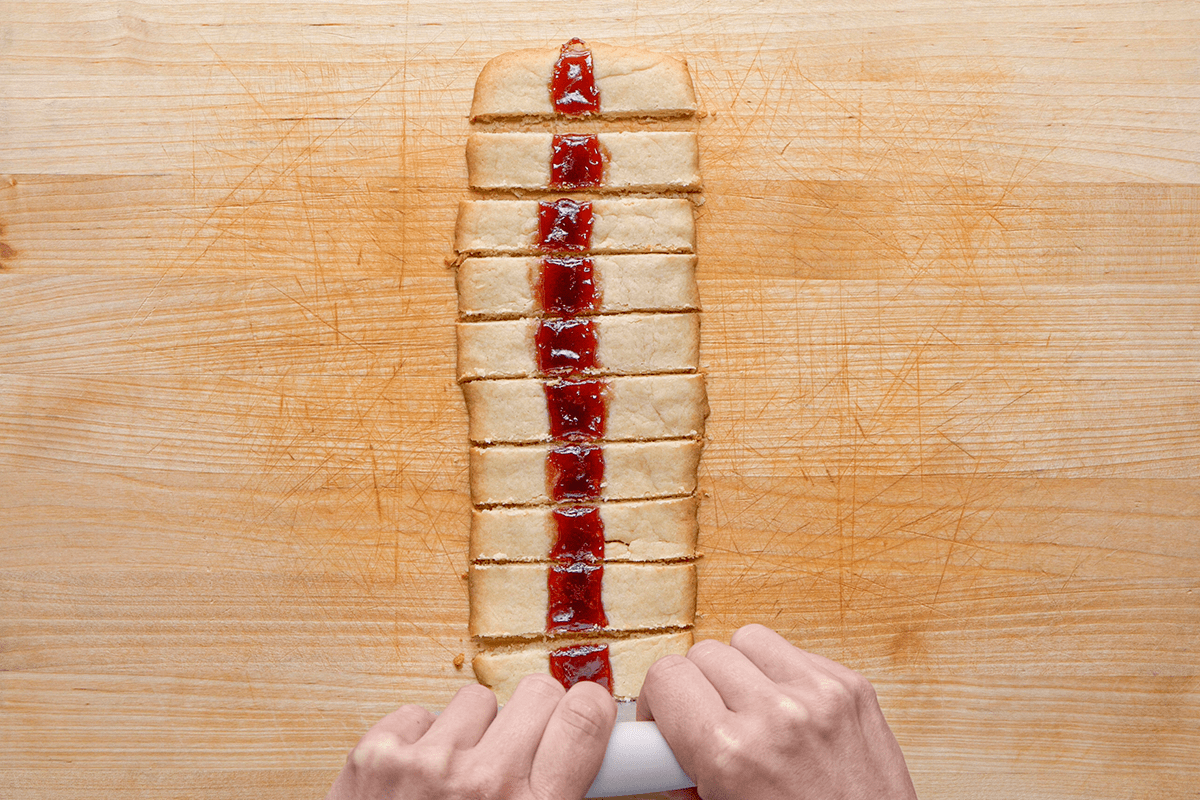 Cutting Raspberry Ribbon Cookies into pieces 