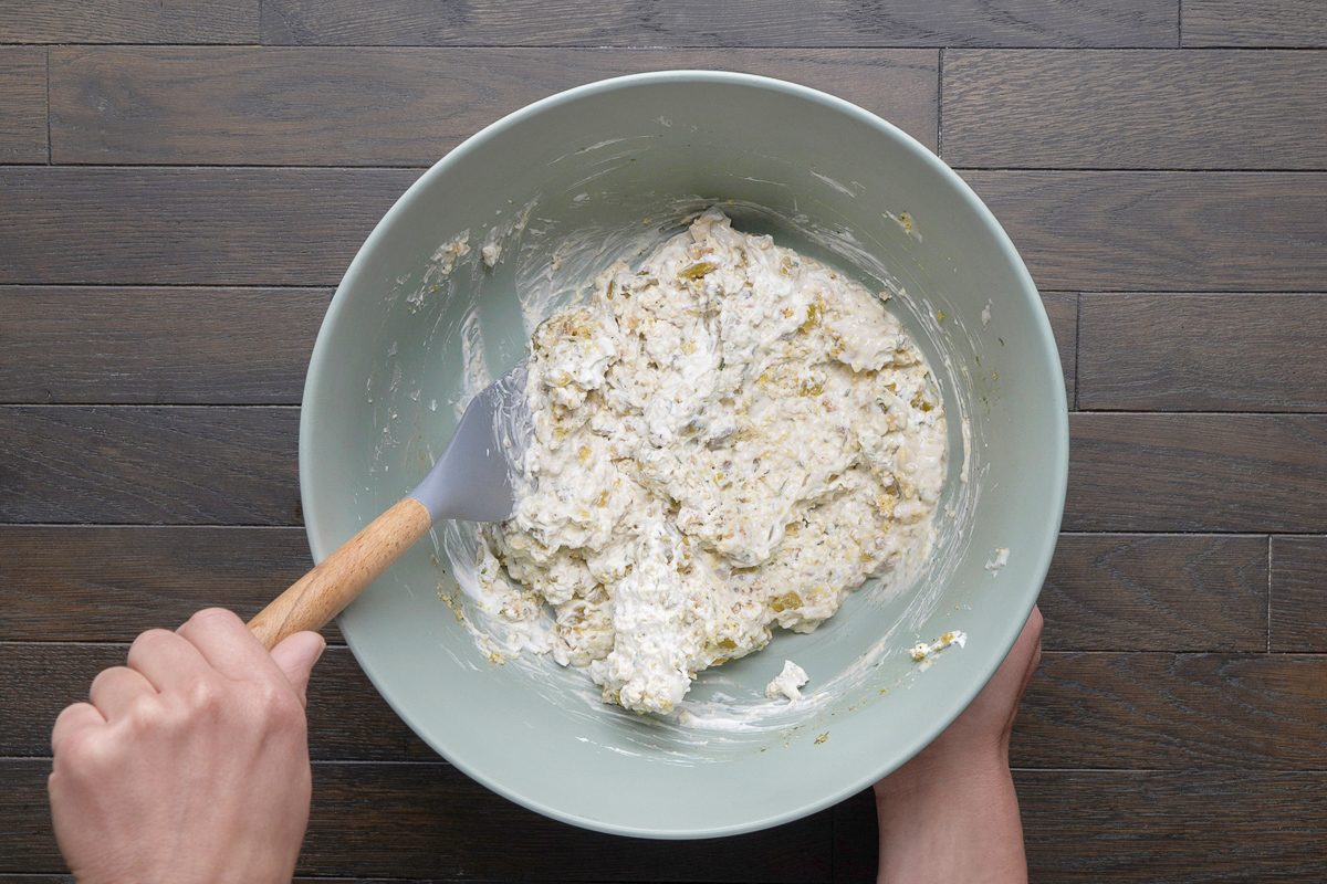 condensed soup, sour cream, stuffing mix seasoning, green chiles, salt and pepper being combined in a large bowl