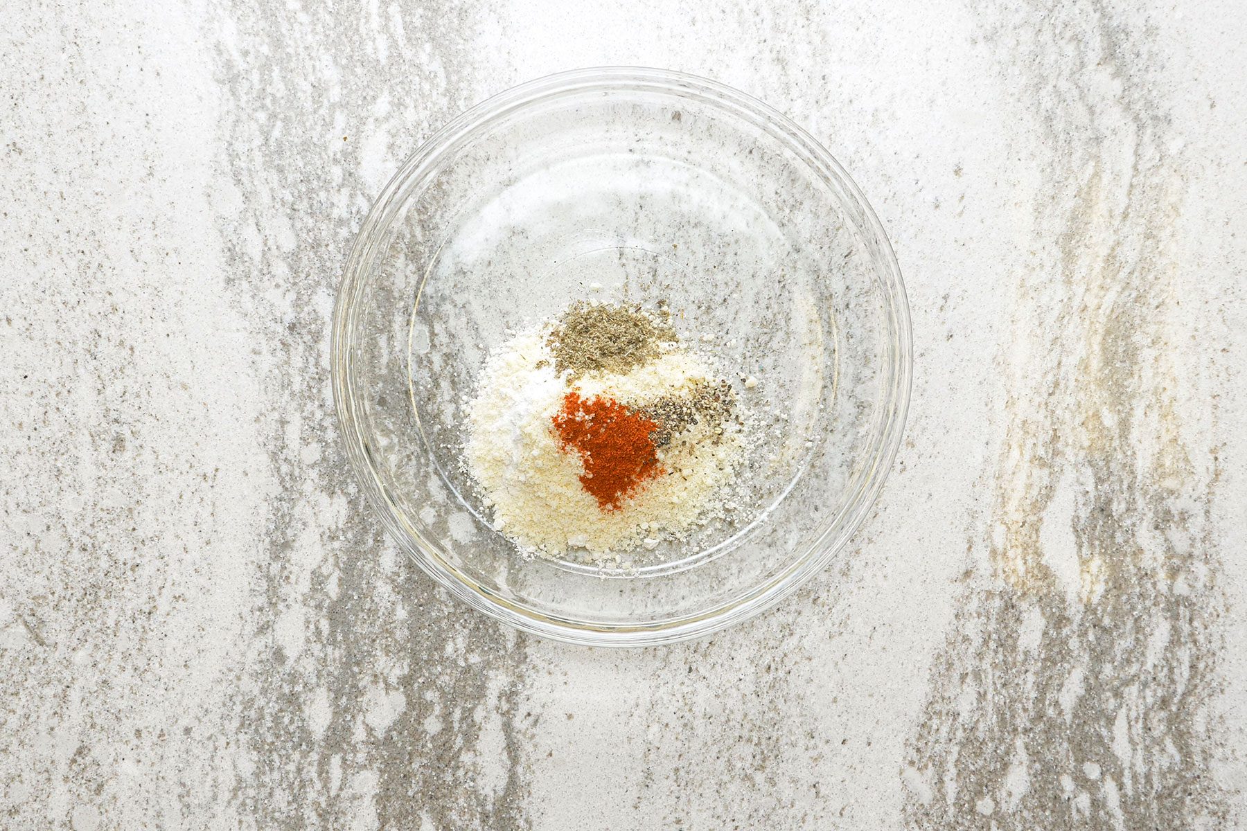 Flour, Parmesan cheese, sage, paprika and pepper in a shallow glass bowl.