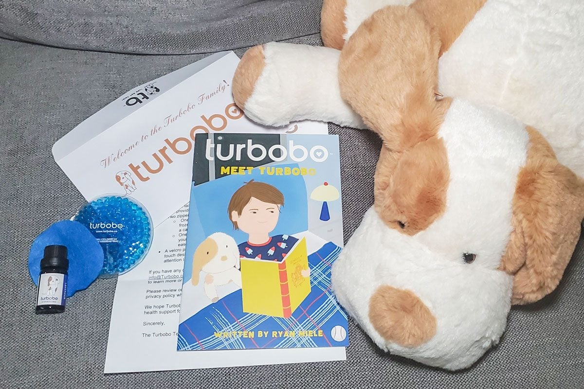 Turbobo stuffed animal next to accessories and book