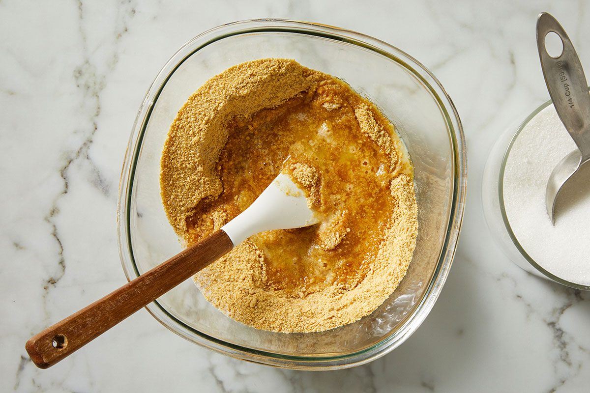 In a bowl, combine the graham cracker crumbs, butter and sugar.