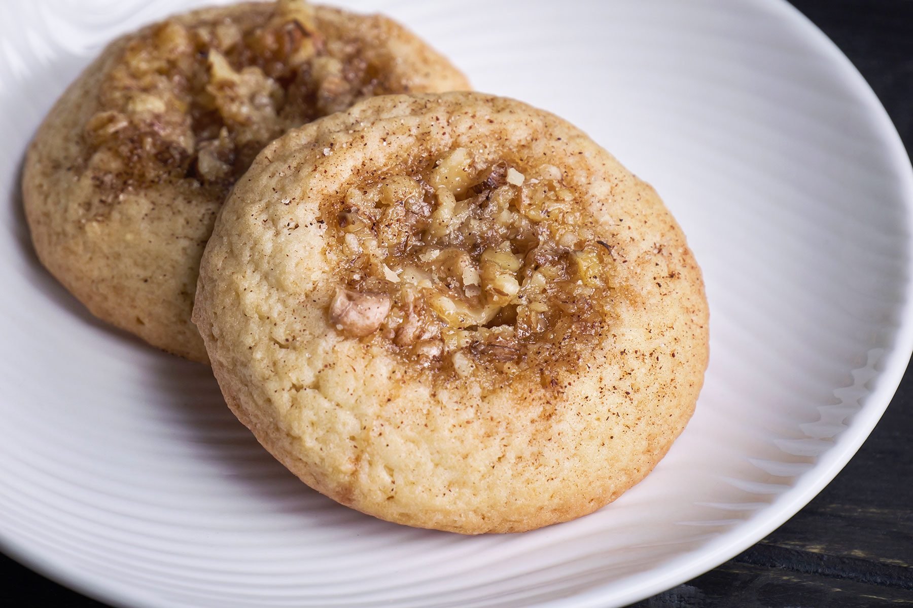 Two Baklava Thumbprint Cookies served in a white plate.