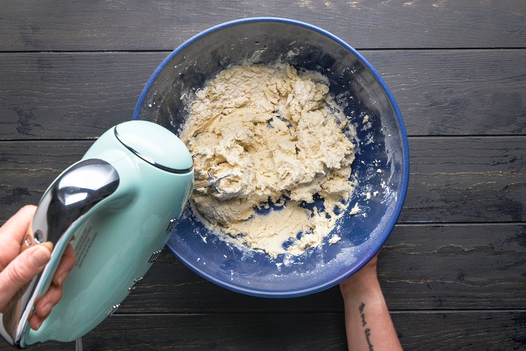 Whisking together flour, baking powder and salt in a blue bowl.