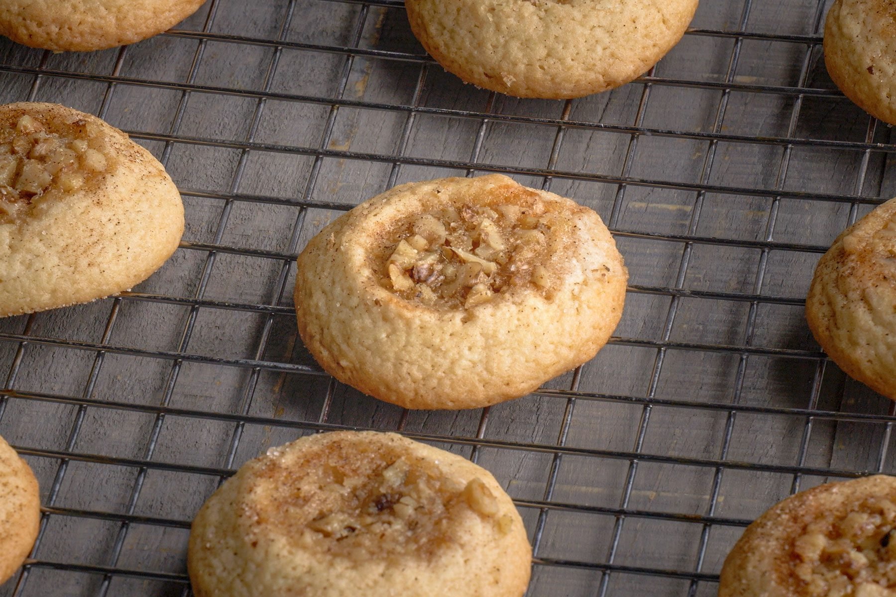 Browned Baklava Thumbprint Cookies on a wire rack.