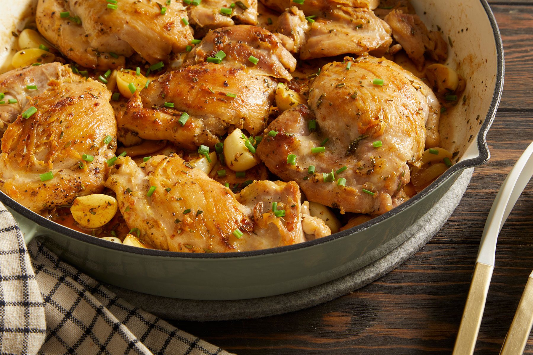 Garlic Herb Chicken in a bowl on a wooden table with a kitchen towel on side.