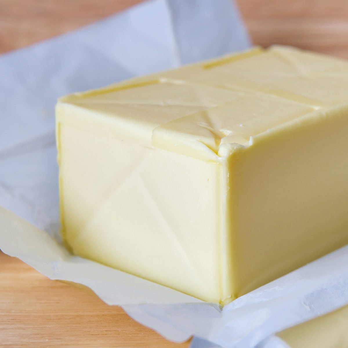 Pack of butter with open wrapper on board