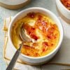 A zoomed in shot of Creme Brulee in a small bowl with a spoon in it.