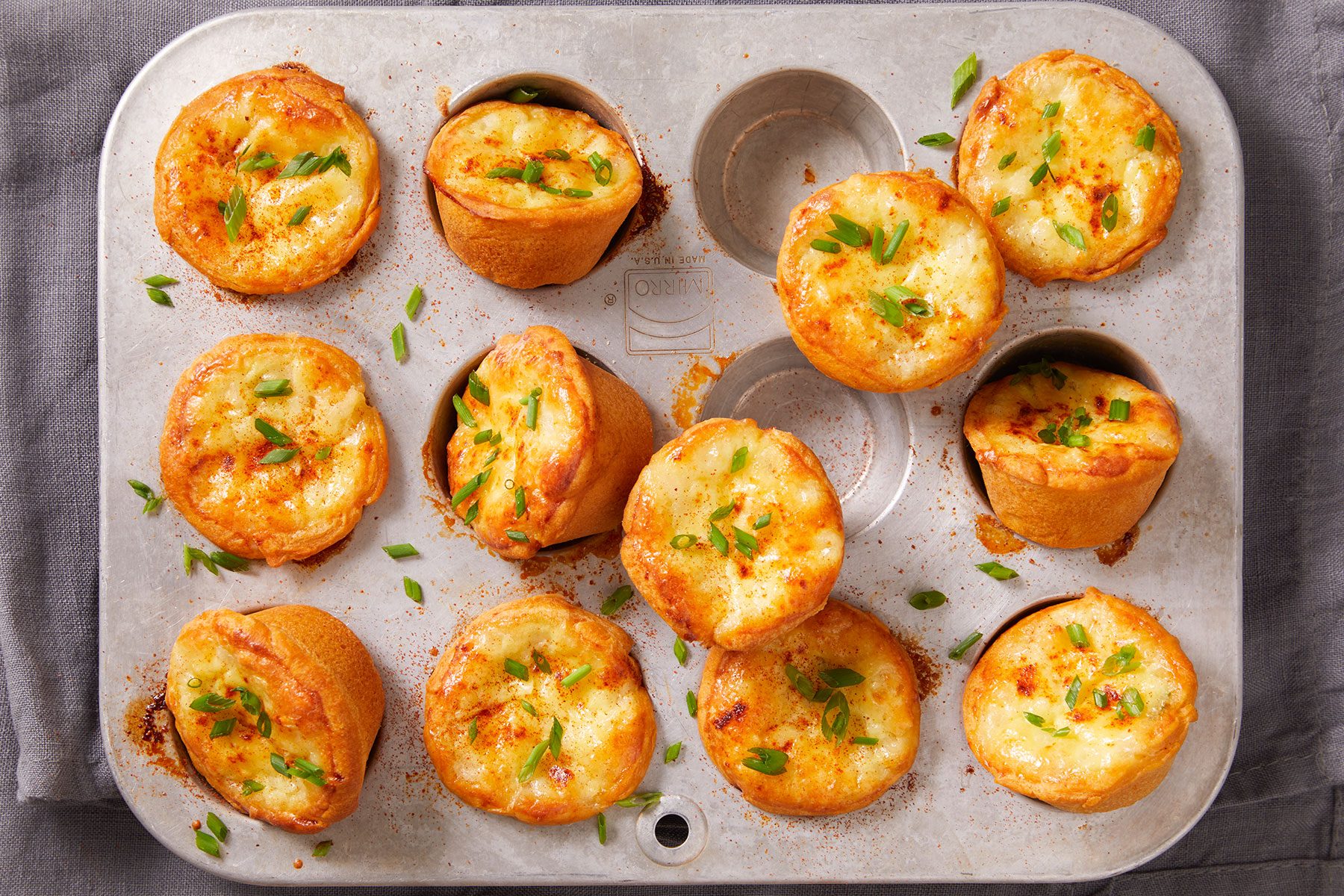 Mini Sausage Quiches in and on miniature muffin cup tray.