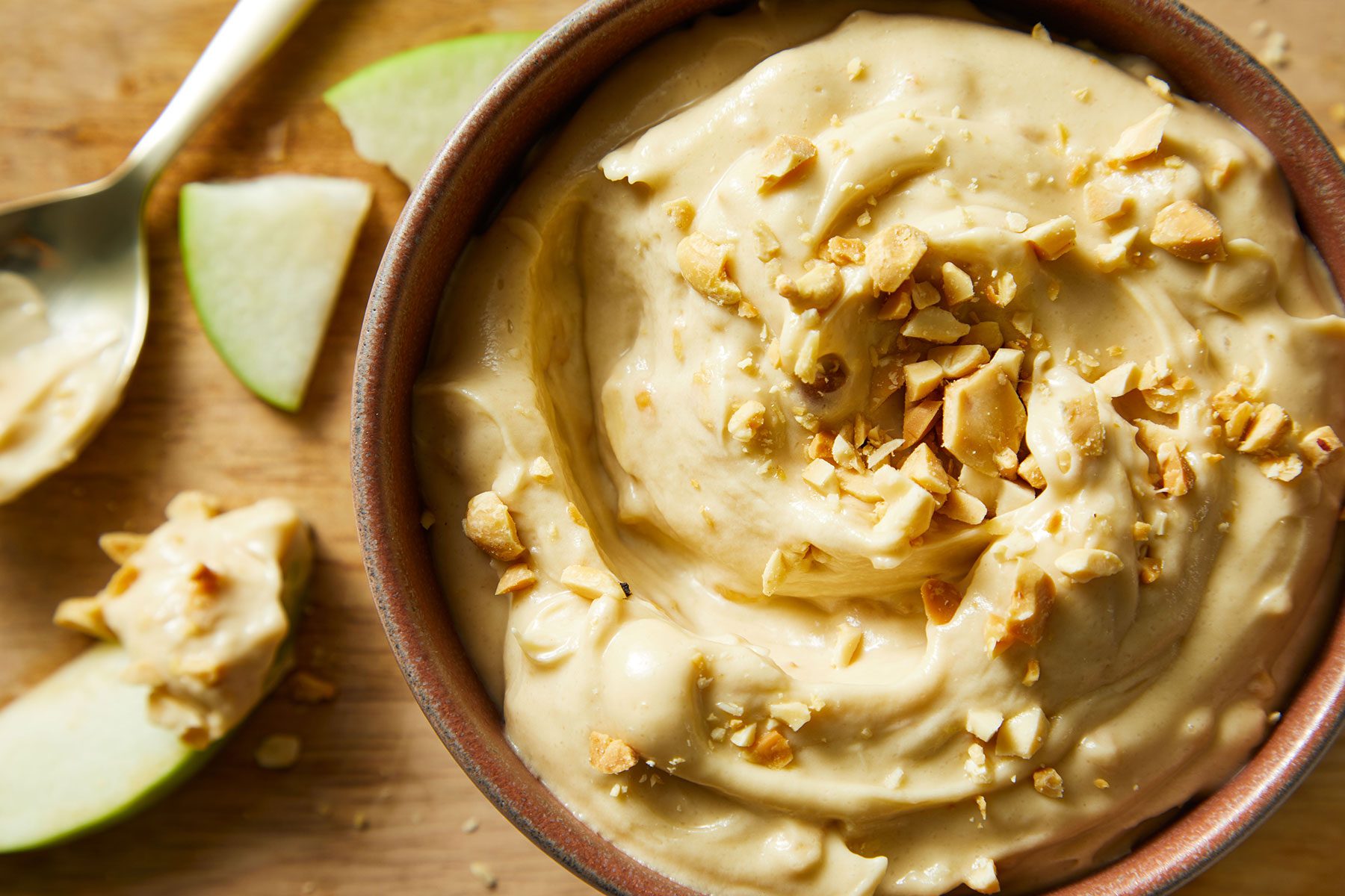 Taffy Apple Dip in a bowl with some fruit slices kept on side.