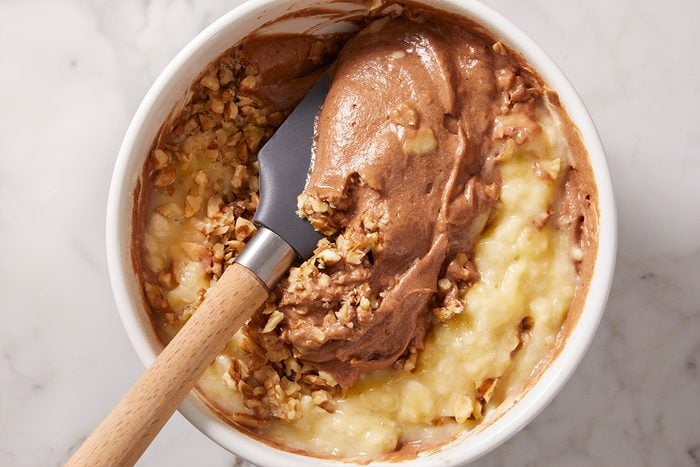 mixing walnuts in brownie batter