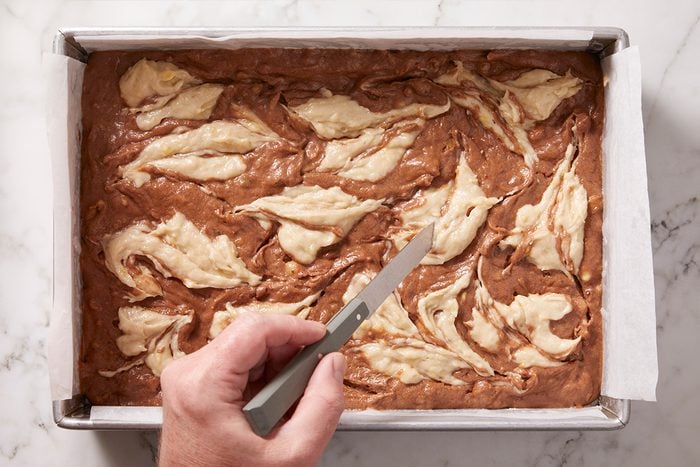 swirling banana bread batter into cookie batter