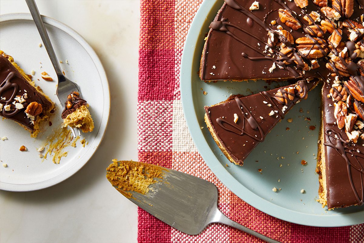 Overhead shot of a plated slice of Gingerbread Cheesecake with a forkful removed, showing the creamy texture and festive topping.