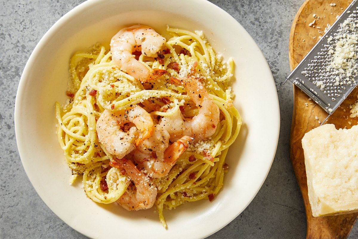Overhead shot of shrimp added back to the pasta, gently mixed into the Creamy Carbonara.